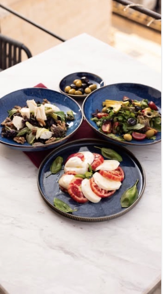 Veranda Rooftop terasında domates-mozzarella, cevizli peynirli salata, yeşil salata ve zeytin